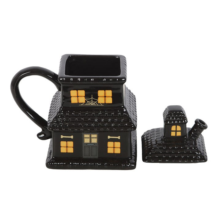 Schwarze Tasse mit Spukhaus-Motiv