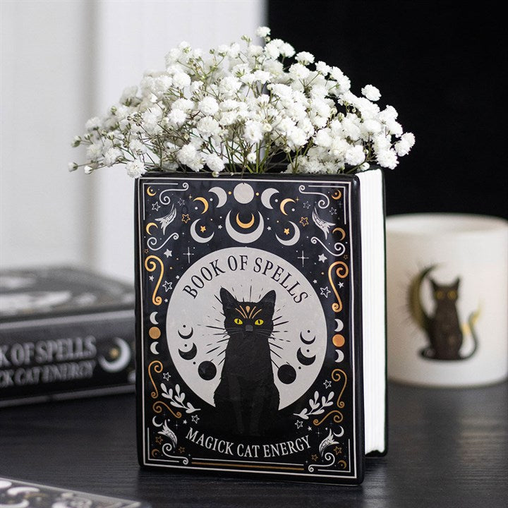 Blumenvase in Form eines Buches mit schwarzer Katze