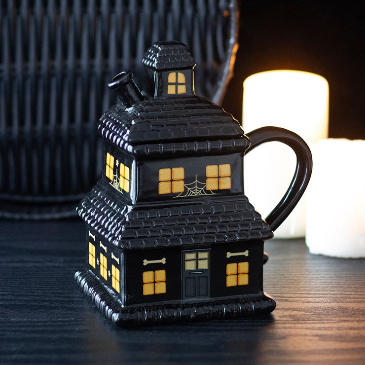 Schwarze Tasse mit Spukhaus-Motiv